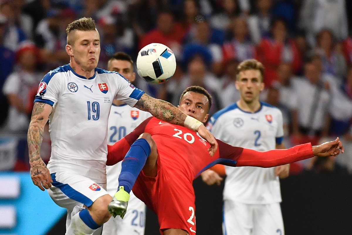 Juraj Kucka (izquierda)de Eslovaquia, disputa el balón con Dele Alli, de Inglaterra durante el juego disputado este lunes. (Foto Prensa Libre: AFP).