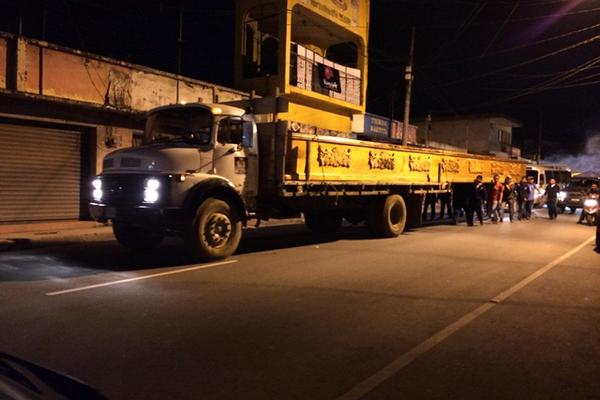 Católicos cargan apoyados de un camión, un anda que se usará en una  procesión del Domingo de Ramos. (Foto Prensa Libre: Eduardo Sam)