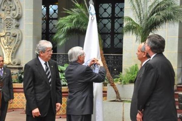 El canciller Haroldo Rodas coloca la insignia en el pabellón de la Usaid, le acompaña el Vicepresidente Rafael Espada, el embajador de EE. UU., Arnold Chacón y el director general de la agencia, Kevin  Kelly.