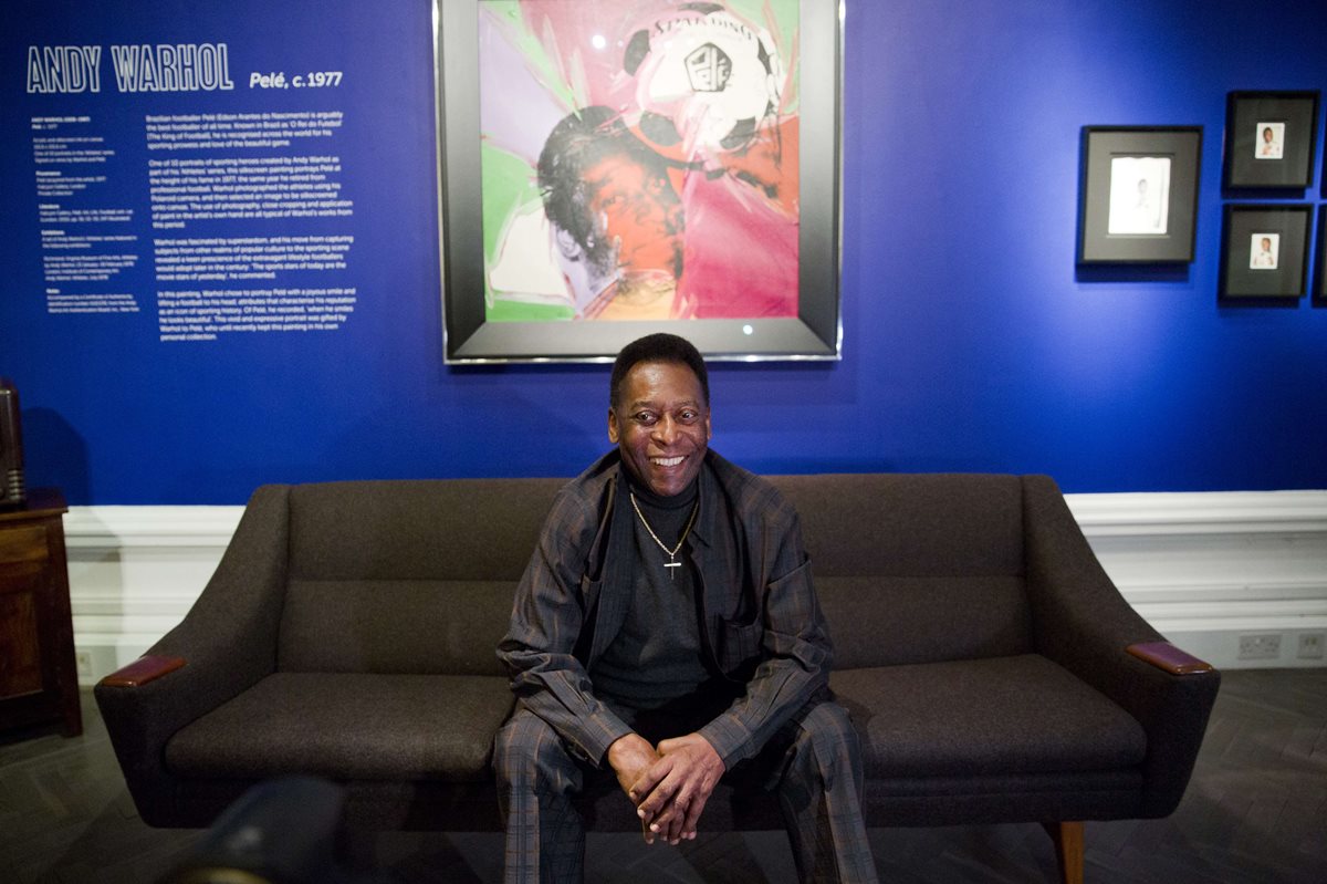 Pelé sonríe a las cámaras en la inauguración de una exposición en su honor. (Foto Prensa Libre: AFP)