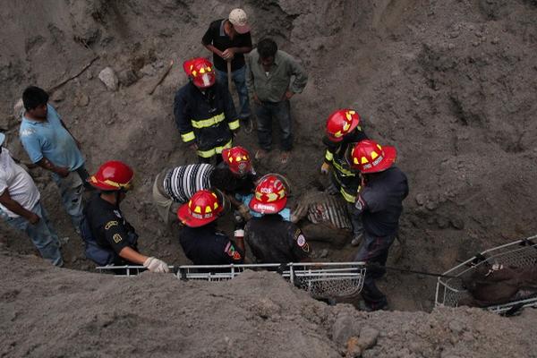 Socorristas trabajan en el rescate de uno de los cadáveres de las personas soterradas en una arenera en El Recreo, San Marcos. (Foto Prensa Libre: Aroldo Marroquín)