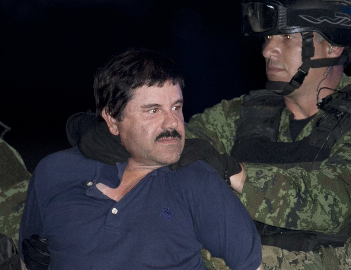 Joaquín el "Chapo" Guzmán es escoltado a un helicóptero por soldados e infantes de marina.(AP).