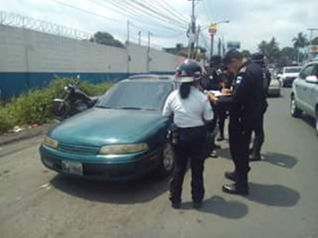 Investigadores de la PNC revisan el vehículo atacado a balazos en la antigua ruta que de Masagua conduce a Escuintla. (Foto Prensa Libre: Melvin Sandoval)