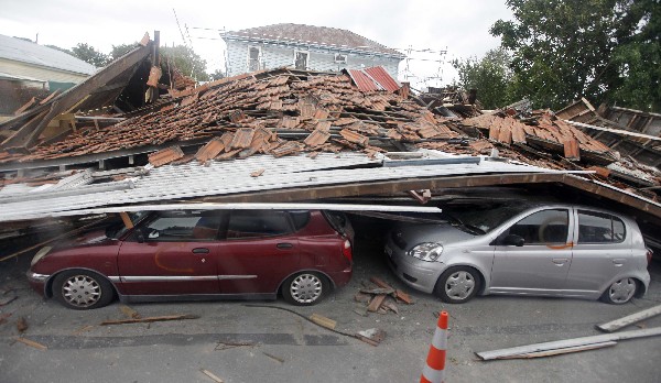 Varios automóviles quedan atrapados bajo un edificio que se derrumbo por sismo de hoy en Christchurch, Nueva Zelanda. (Foto Prensa Libre:AP).