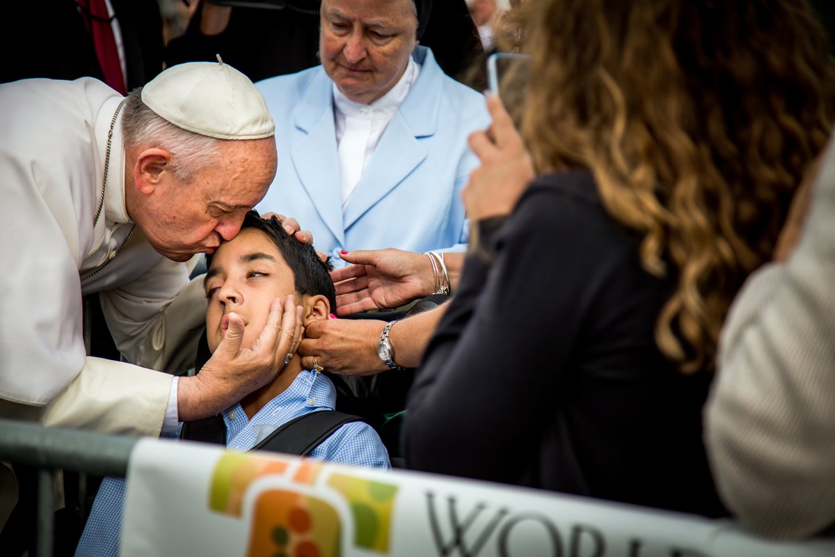 Michael Keating, quien padece de parálisis cerebral, recibe un beso del papa Francisco, observa su madre y familiares. (Foto Prensa Libre: AP).