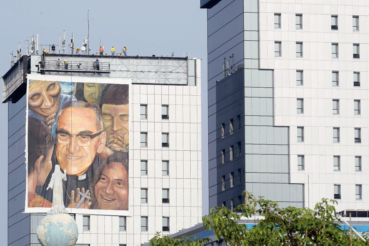 Trabajadores colocan una pintura gigante dedicada a Monseñor Óscar Romero, que será beatificado el próximo 23 de mayo en San Salvador. (Foto Prensa Libre:AP)