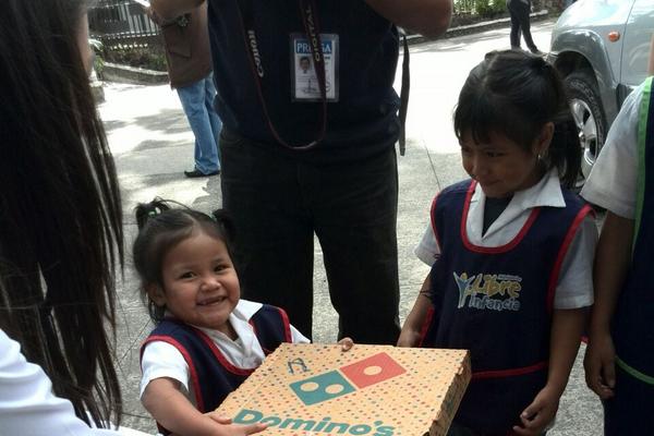 Una niña recibe una pizza que compartirá con otros de sus compañeros de escasos recursos (Foto: Prensa Libre: Andrea Orozco)