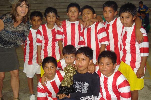 los niños del asentamiento Las Torres muestran el trofeo del primer lugar de la VII Copa Infantes de balonmano.