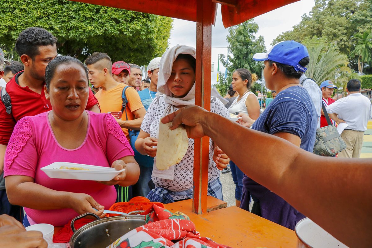 Vecinas dan alimentos a migrantes hondureños en Tecún Umán