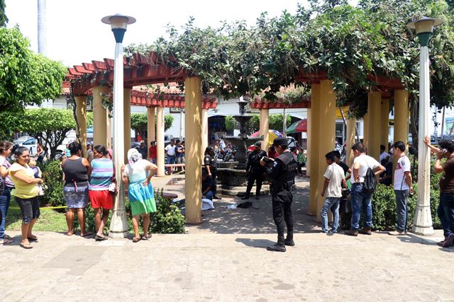 Agentes de la Policía Nacional Civil protegen la escena en que falleció un hombre en el parque central de Ratalhuleu. (Foto Prensa Libre: Rolando Miranda)