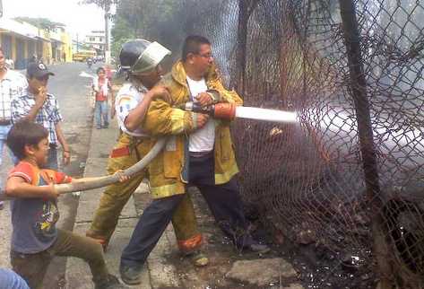 Socorristas sofocan el fuego que se generó en la antigua estación del ferrocarril de Escuintla. (Foto Prensa Libre: Melvin Sandoval)
