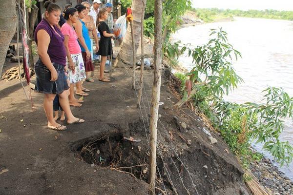 Residentes de la ribera del río Cristóbal muestran cómo el afluente ha socavado el terreno donde están construidas sus viviendas. (Foto Prensa Libre: Enrique Paredes)