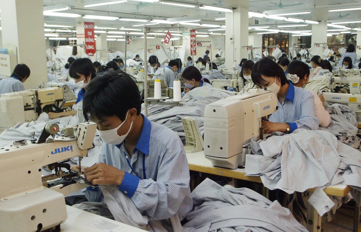 Trabajadores de la empresa Garment Company, ubicada en las afueras de Hanoi, Vietnam, elaboran camisas para el mercado estadounidense. (Foto Prensa Libre: AP)