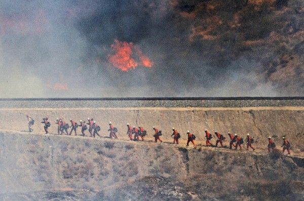 Bomberos se dirigen a combatir el incendio forestal en Santa Clarita. (Foto Prensa Libre: AP)