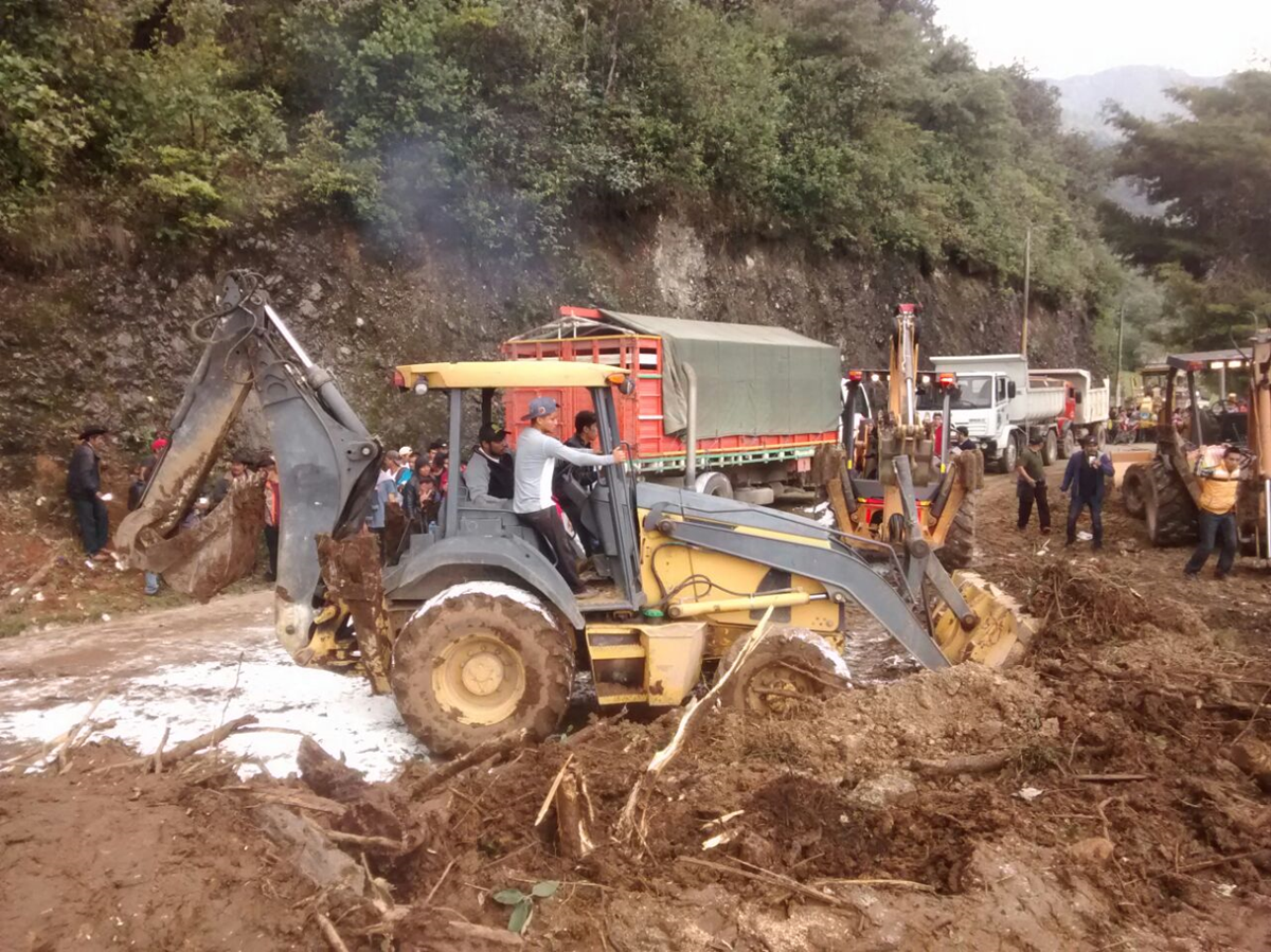 Un tractor trata de despejar la ruta donde ocurrió la tragedia en San Pedro Soloma, Huehuetenango. (Foto Prensa Libre: Mike Castillo)