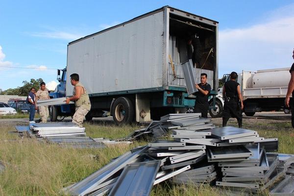 Policías descargan el producto incautado para contabilizarlo. (Foto Prensa Libre: Mike Castillo)<br _mce_bogus="1"/>
