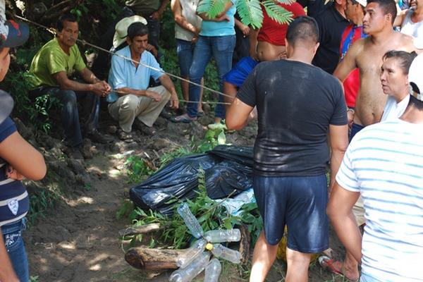 Vecinos observan el cadáver de Henry Fernando García, quien murió arrastrado por el río Ostúa, en Santa Catarina Mita. (Foto Prensa Libre: Óscar González)