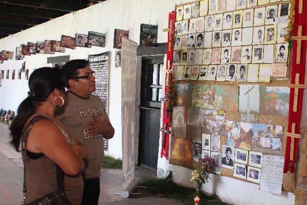 Una pareja observa, en Cobán, la exposición de fotografías  de víctimas del conflicto armado interno.