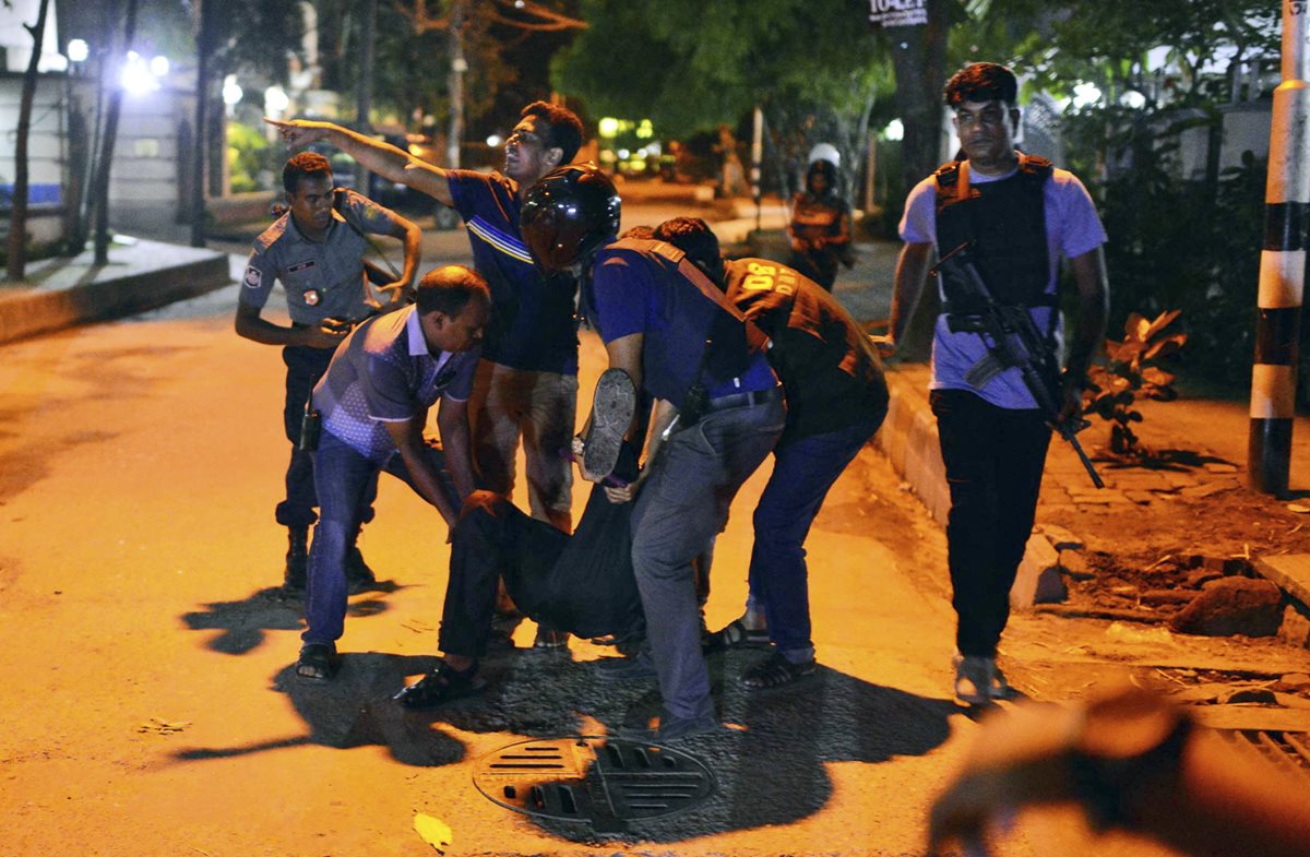 Autoridades rescatan a los heridos del área donde ocurrió la balacera en Bangladés. (Foto Prensa Libre: AP).
