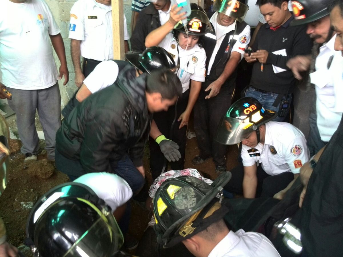 Los Bomberos Voluntarios auxilian a Reina Juliana López Mendoza, quien se salvó de morir soterrada. (Foto Prensa Libre: Estuardo Paredes). 