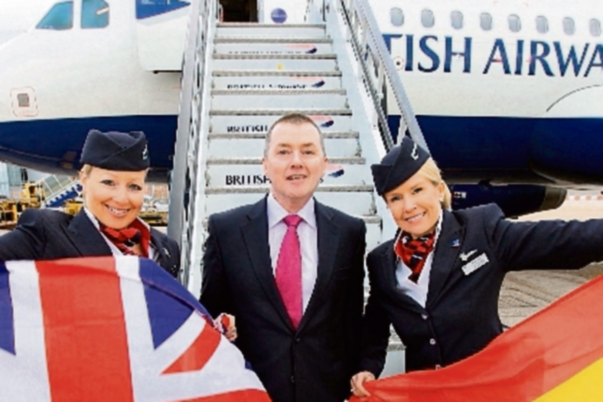 Willie Walsh, en medio de dos sobrecargos de una aerolínea inglesa y otra española. (Fotografía Prensa Libre Hemeroteca PL)