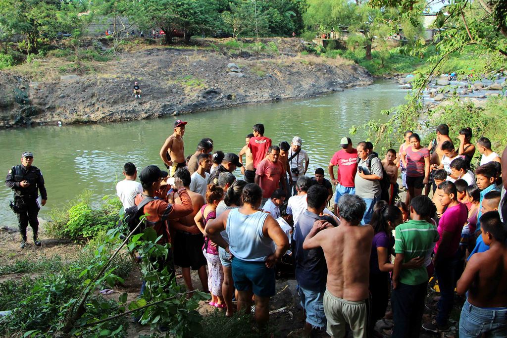 Vecinos y familiares llegan a identificar el cuerpo de Wilmer Elías López, de 17 años, a orillas del río Ocosito. (Foto Prensa Libre: Rolando Miranda)