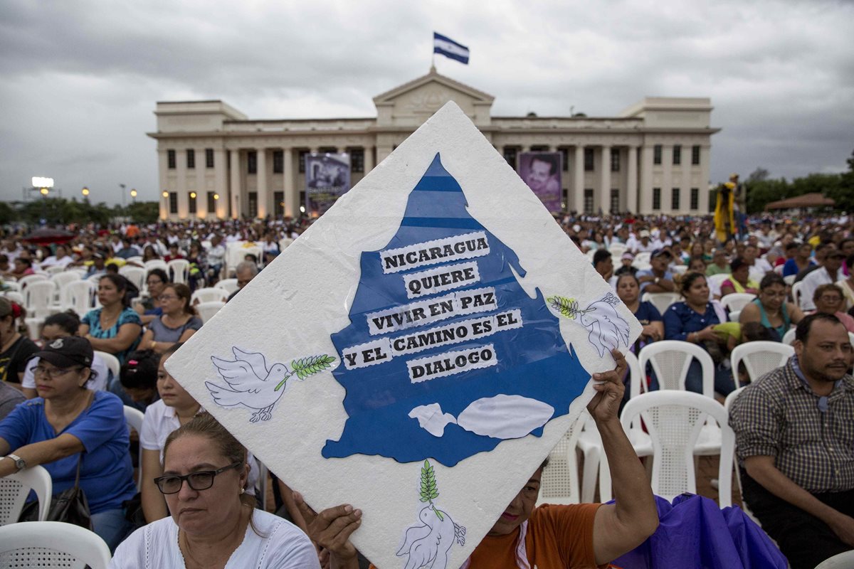 Una mujer sostiene un cartel que pide la paz y el diálogo en la Plaza de la Revolución en Managua, Nicaragua. (Foto Prensa Libre:AFP).