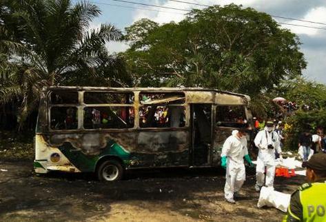 Policías junto a cuerpos de niños muertos en el autobus incendiado el Fundación, Colombia. (Foto Prensa Libre: AFP).