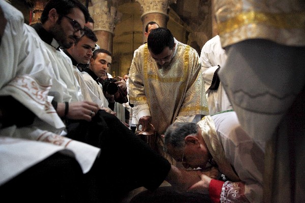 El patriarca latino de Jerusalén, Fouad Twal (d), lava los pies de un sacerdote. (Foto Prensa Libre: AP)