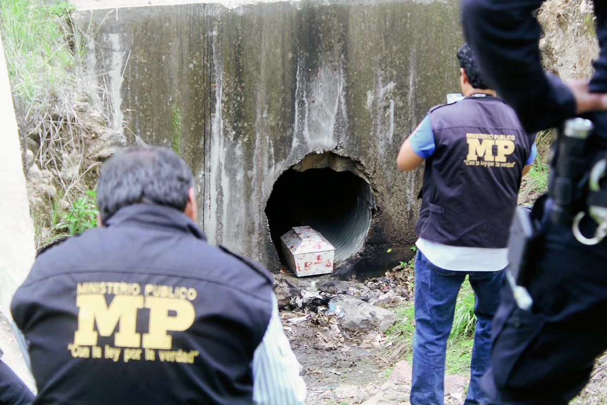 Fiscales del Ministerio Público recogen evidencias en el lugar en el que fue hallado un féretro con los restos de un bebé. (Foto Prensa Libre: Hugo Oliva)