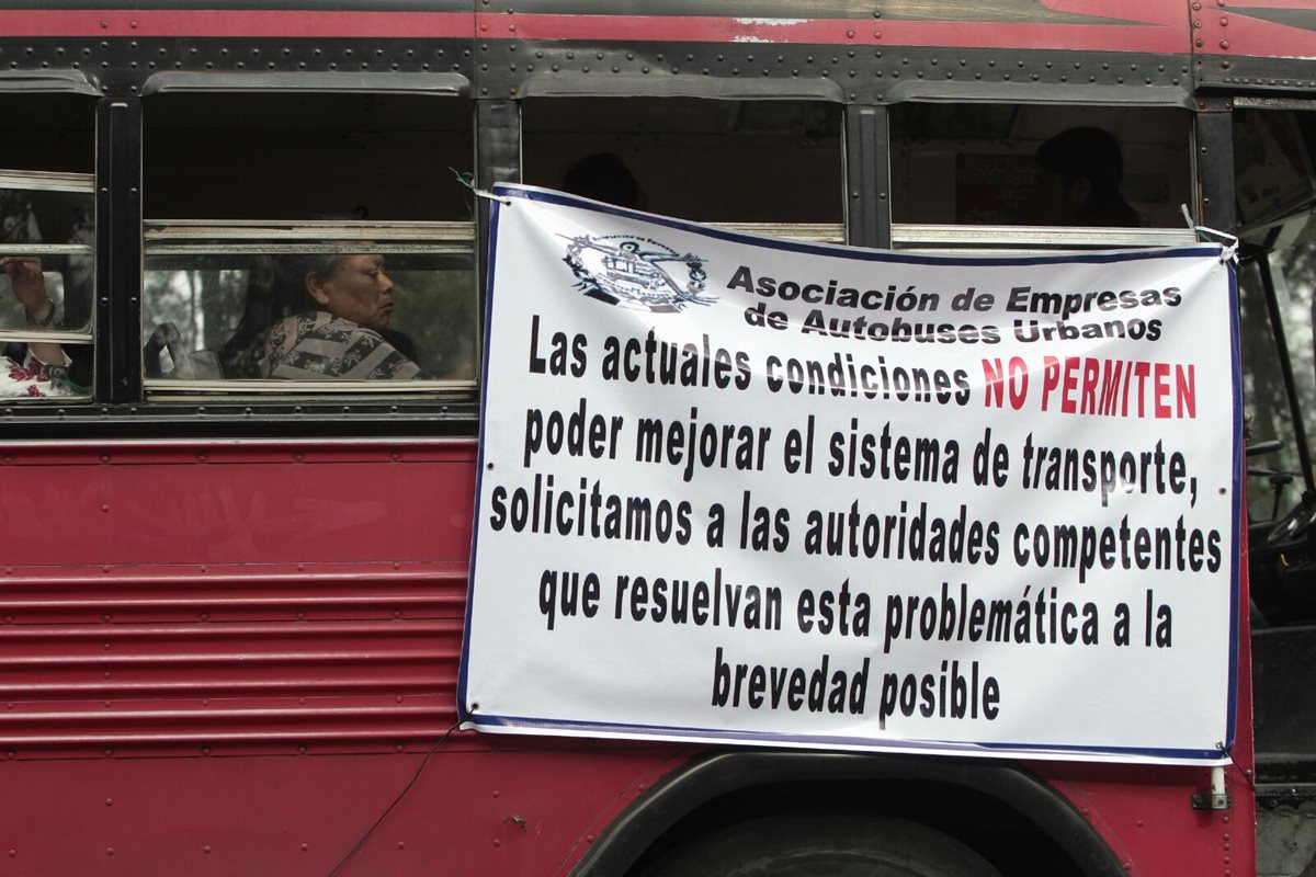 Buses de transporte urbano circulan con mantas en las que se exige el pago del subsidio de parte del Gobierno. (Foto Prensa Libre: Erick Ávila)