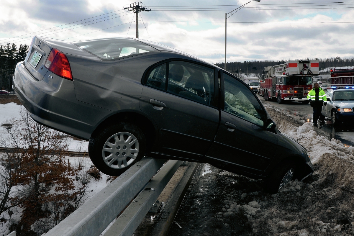 Un vehículo se sale de carretera y queda colgando en puente sobre río en Nashua, Nueva Hampshire, EE. UU. (Foto Prensa Libre: AP)
