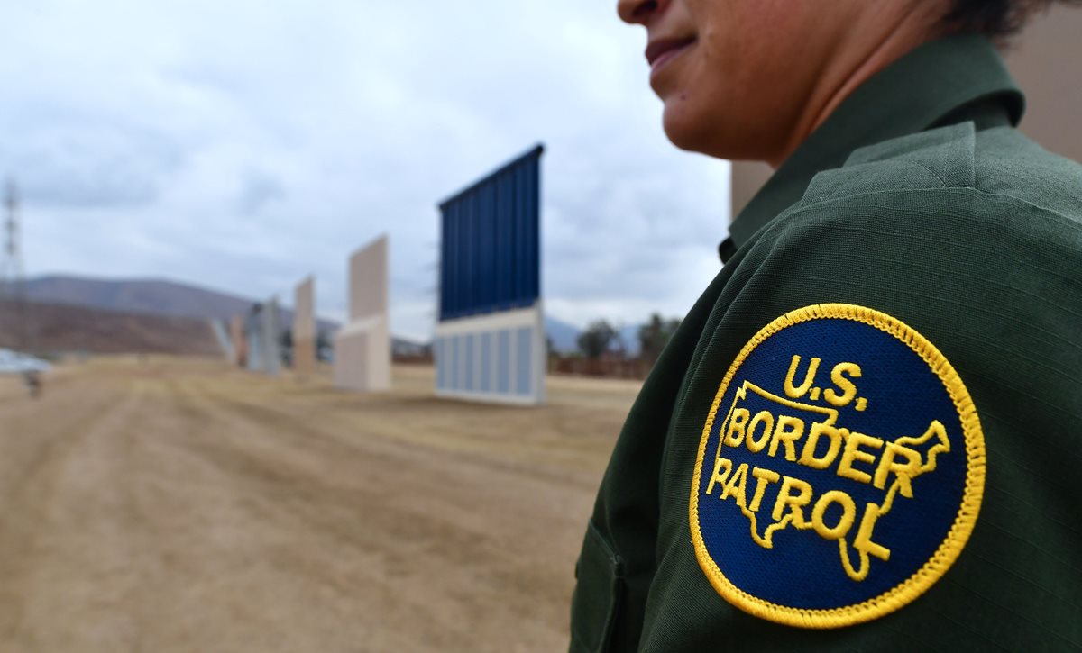 Un oficial de la Patrulla Fronteriza estadounidense se encuentra cerca de los prototipos del muro fronterizo propuesto por Donald Trump en San Diego, California. (Foto Prensa Libre: AFP).