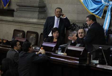 Manuel Barquín —derecha— conversa con diputados oficialistas que piden  conocer el proyecto de  presupuesto antes de juramentar a Wálter Félix.