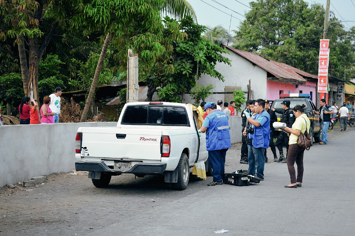 Autoridades recaban datos de mujer muerta a balazos en picop, en Puerto San José, Escuintla. (Foto Prensa Libre: Enrique Paredes)