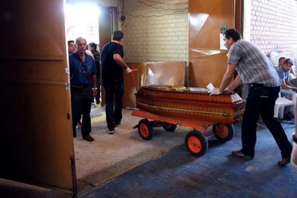 Empleados de una funeraria trasladan un ataúd este lunes en Santa María, al sur de Brasil. (Foto Prensa Libre: AFP)
