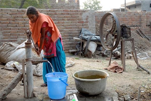 Una mujer saca agua de un pozo en la India, donde el gobierno ofrece jornadas de esterilización. (Foto Prensa Libre: AFP)