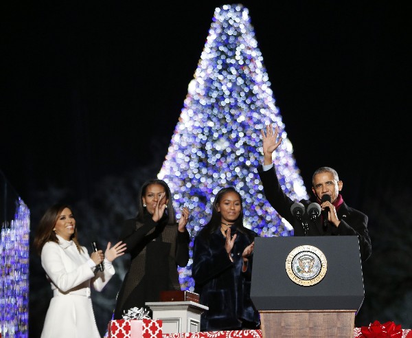 Barack Obama acopmañado de Michelle Obama (2 ª izquierda) y su hija Sasha (c)encienden el árbol de Navidad. (Foto Prensa Libre: AFP)