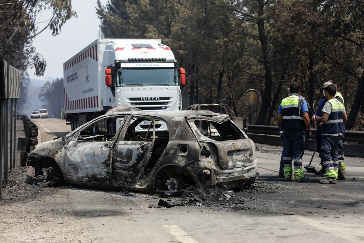 Un camión del servicio forense traslada los cuerpos quemados de vehículo carbonizado. Por el incendio forestal murieron 62 personas(Foto Prensa Libre:EFE).