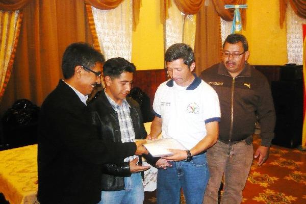 Autoridades municipales, izquierda, reciben el proyecto para la escuela de vacaciones.