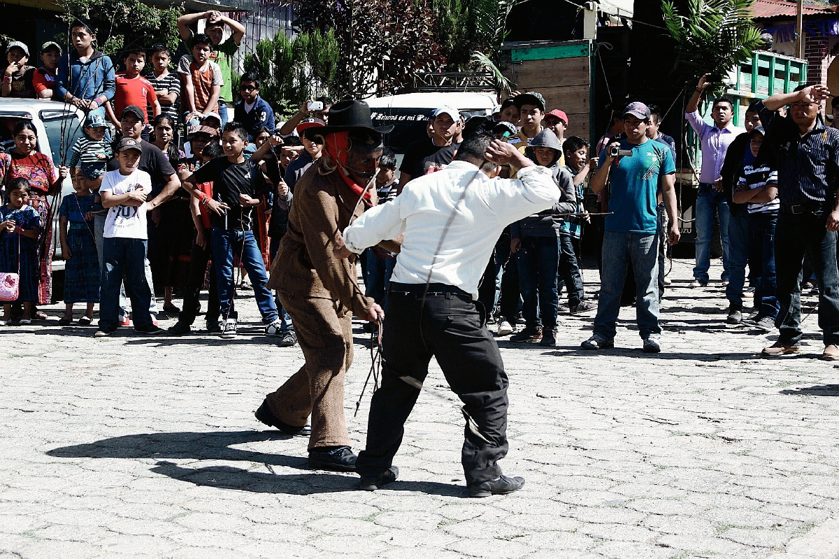 Un hombre  que se disfraza de Judas o Shutío, pelea a latigazos con pobladores en San Andrés Semetabaj, Sololá, para expiar los pecados. (Foto Prensa Libre: Ángel Julajuj)