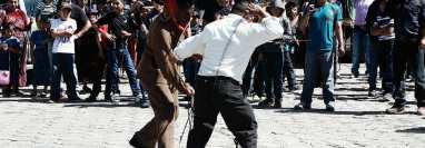 Un hombre  que se disfraza de Judas o Shutío, pelea a latigazos con pobladores en San Andrés Semetabaj, Sololá, para expiar los pecados. (Foto Prensa Libre: Ángel Julajuj)