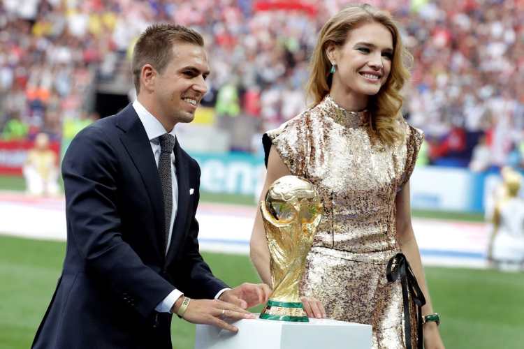 El exfutbolista alemán Philipp Lahm y la modelo rusa Natalia Vodianova portan el trofeo del Mundial antes del partido Francia-Croacia