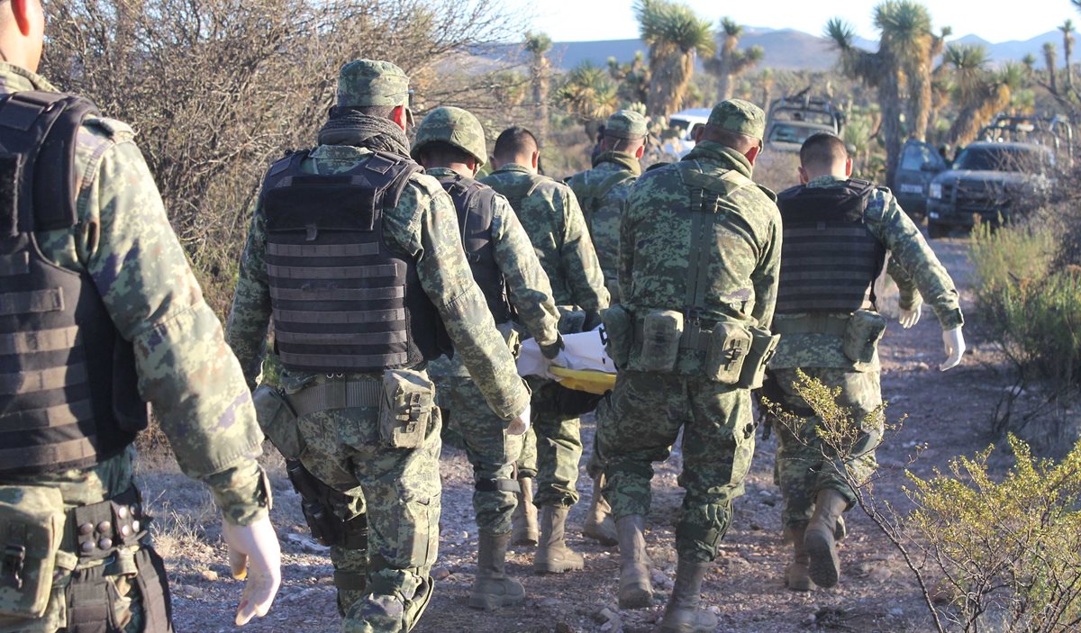 Efectivos del ejército mexicano traslada a uno de los fallecidos en los enfrentamientos. (EFE).