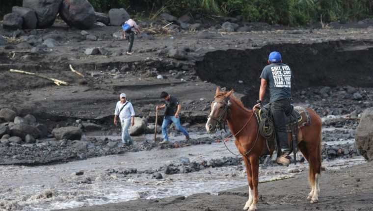 Ante la falta de camino, vecinos de seis comunidades de San Pedro Yepocapa cruzan el río Taniluya, que arrastra material volcánico. (Foto Prensa Libre: Esbin García)