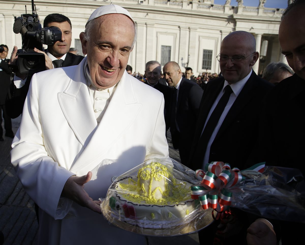 El papa Francisco sostiene un pastel de cumpleaños que recibió un día antes de cumplir 79. (Foto Prensa Libre: AP).