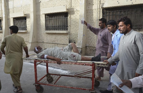 Un grupo de personas traslada a un herido después de la explosión al hospital en Pakistán. (Foto Prensa Libre: AFP).