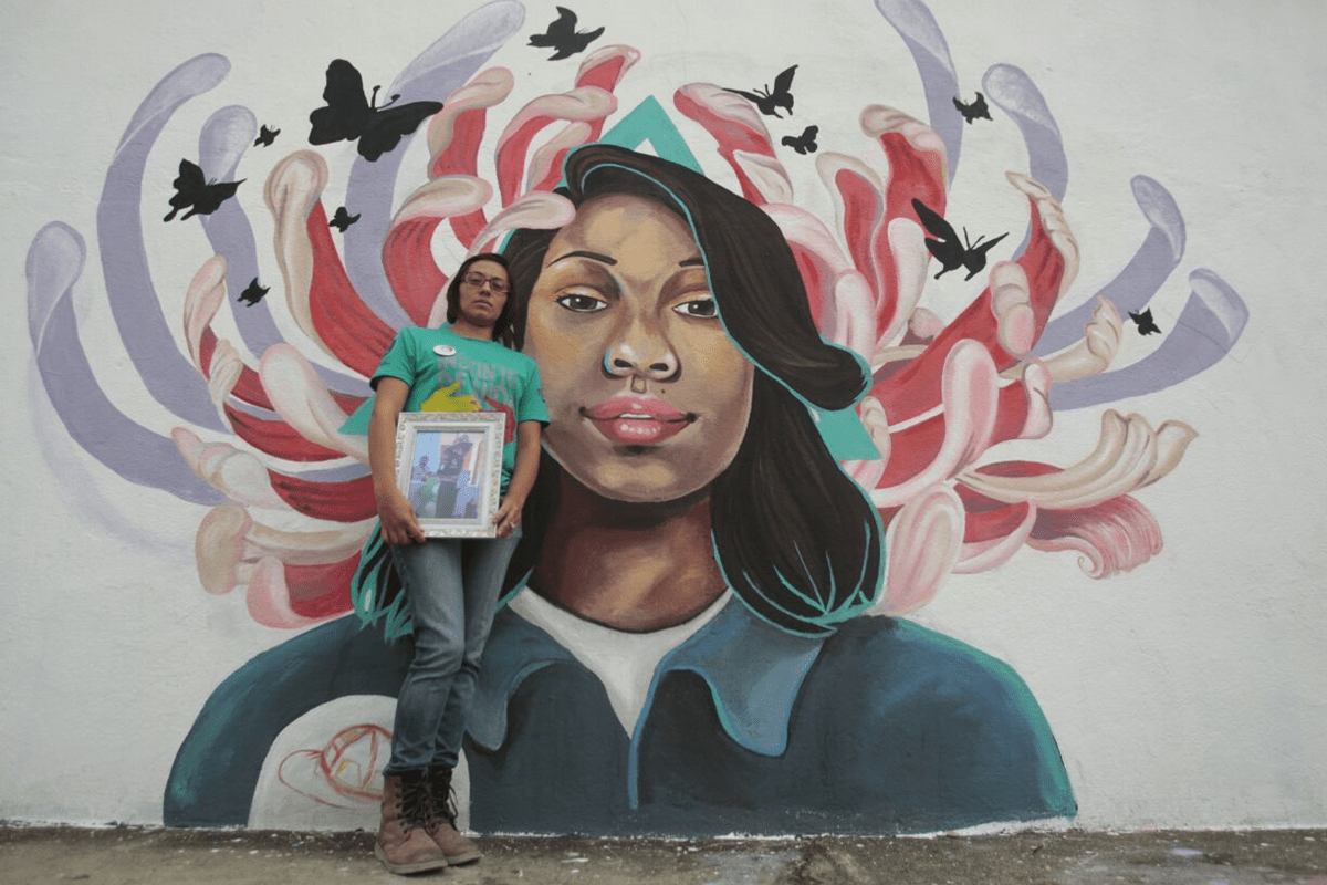 El rostro de Ashley Gabriela Méndez, quien falleció durante el incendio en el Hogar Seguro, fue pintado en uno de los murales, sobre el cual está recostada la madre, Dacia Ramírez. (Foto Prensa Libre: Carlos  Hernández)