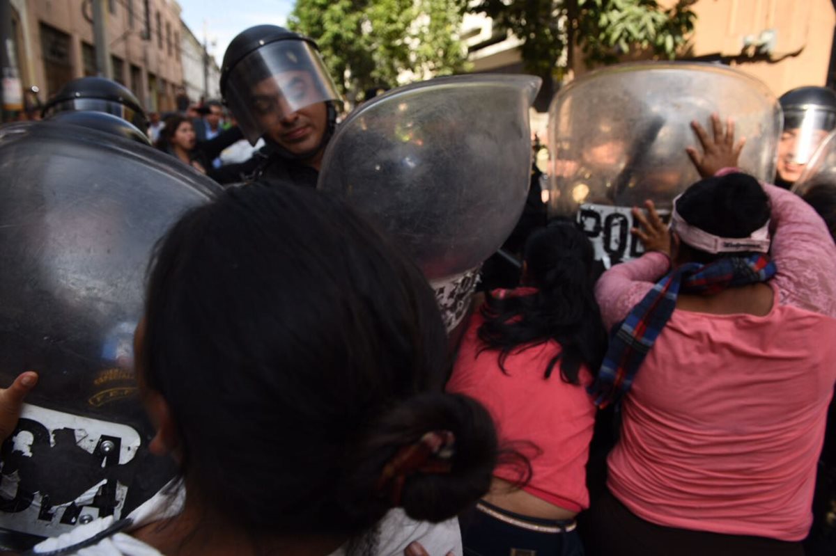 Un grupo de manifestantes se enfrenta a empujones al contingente de la Policía Nacional Civil afuera del Congreso. (Foto Prensa Libre: Paulo Raquec)