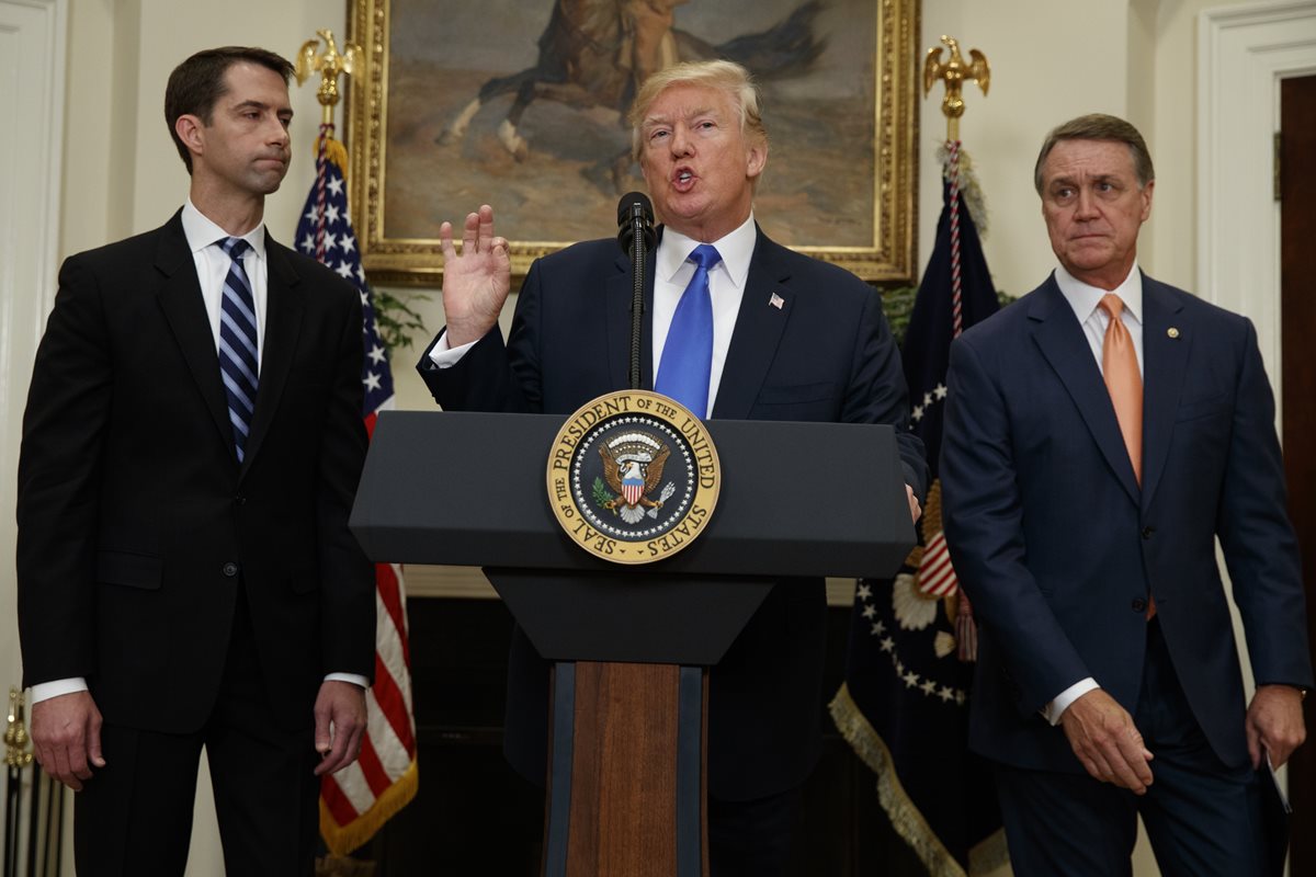 Donald Trump es acompañado por los senadores republicanos Tom Cotton,(d) y a la izquierda David Perdue. (Foto Prensa Libre: AP).